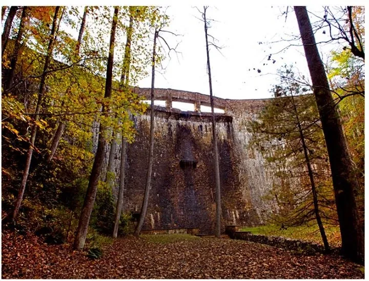 The curved masonry face of the hydroelectric dam at Devotion in autumn